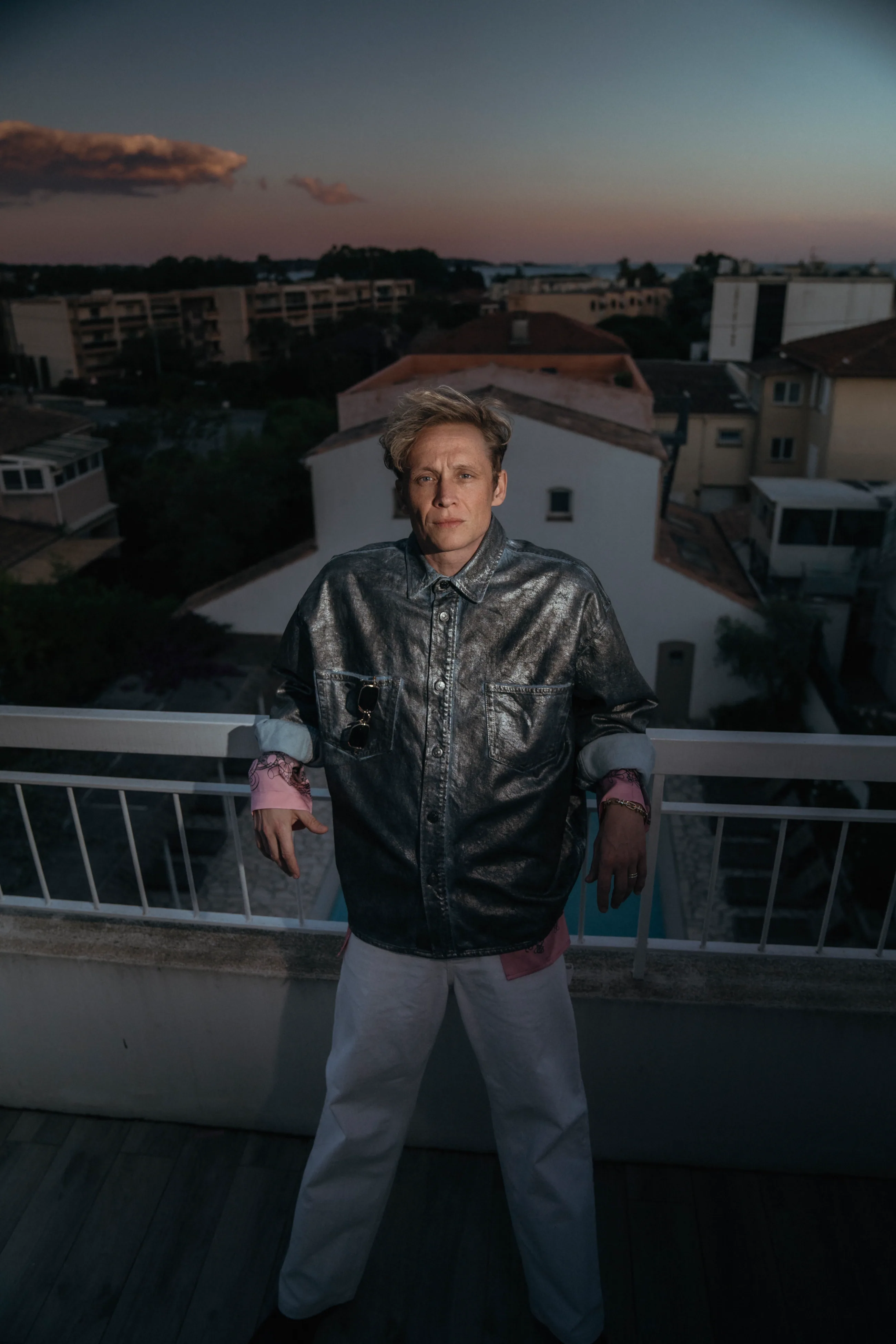 Matthias Schweighöfer in Metallic-Jacke auf einer Dachterrasse im Abendlicht